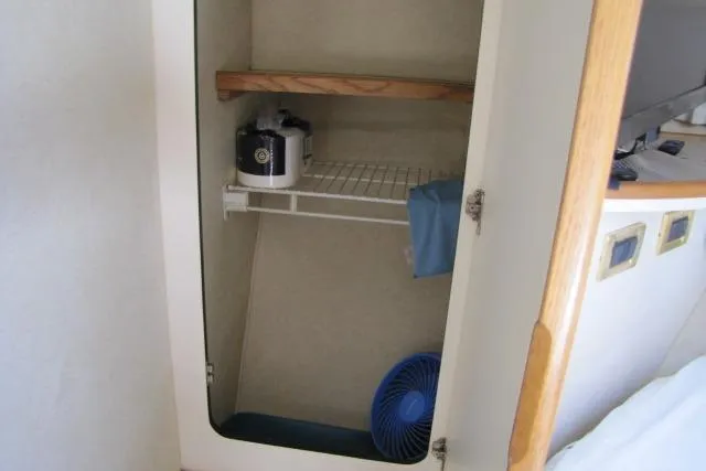 Slide: The Image of Storage compartment in a 1997 Sea Ray 370 Express Cruiser with various items and a fire extinguisher. - 30