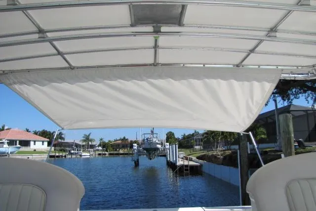 Slide: The Image of 1997 Sea Ray 370 Express Cruiser docked with beige cover, calm waters. - 5