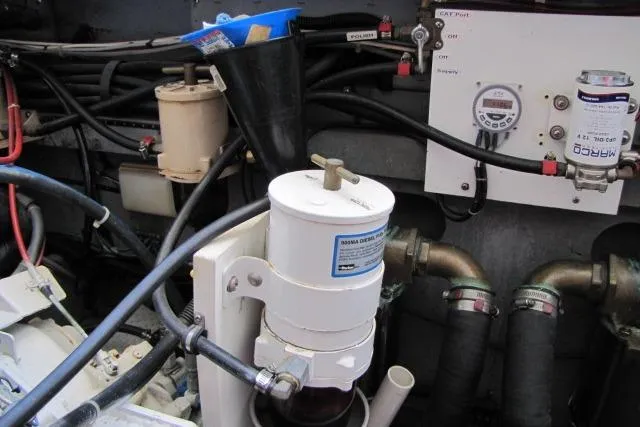 Slide: The Image of Engine compartment of a 1997 Sea Ray 370 Express Cruiser with visible wiring and components. - 55