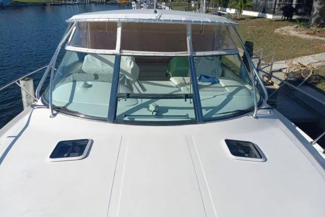 Slide: The Image of 1997 Sea Ray 370 Express Cruiser with canopy, docked in a sunny waterfront setting. - 6
