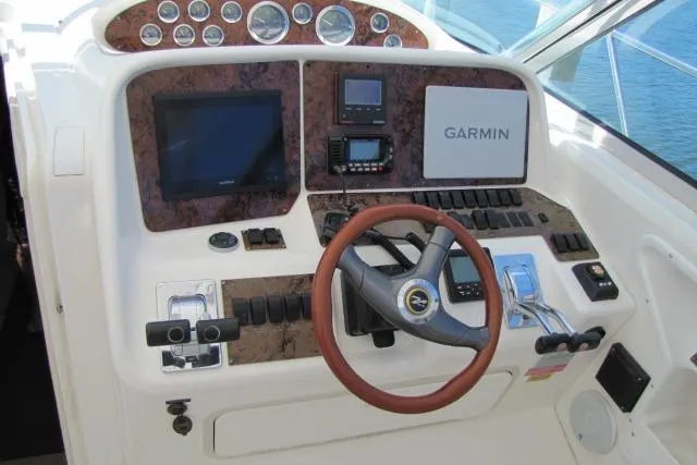 Slide: The Image of 1997 Sea Ray 370 Express Cruiser docked with beige cover, calm waters. - 68