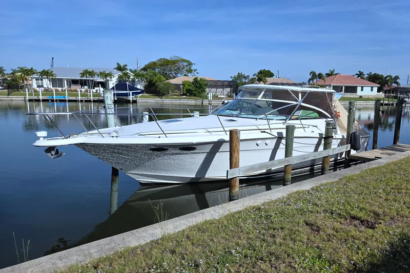Slide: The Image of 1997 Sea Ray 370 Express Cruiser docked in a serene waterfront setting. - 70