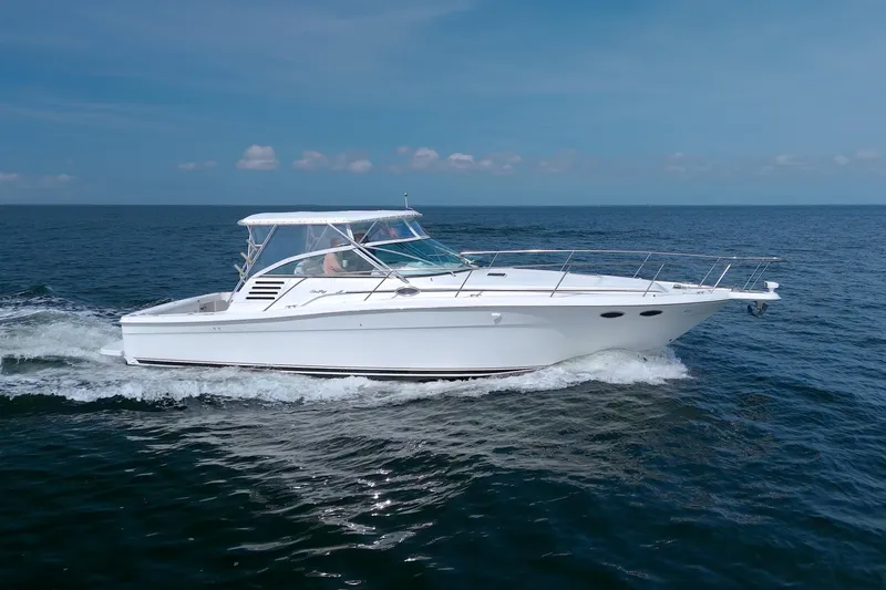 Slide: The Image of 1997 Sea Ray 370 Express Cruiser navigating open waters under a clear blue sky. - 77