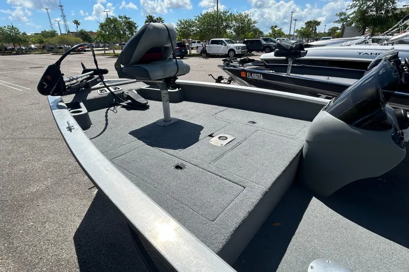 Slide: The Image of 2010 Tracker Pro Crappie 175 fishing boat with seating and control panel in a parking lot. - 6