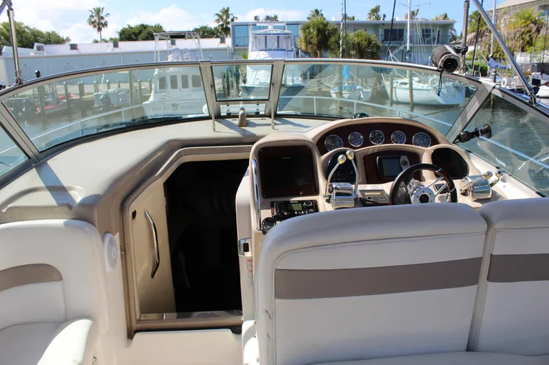 Slide: The Image of 2005 Sea Ray Sundancer 320 docked at marina, showcasing sleek design and spacious seating. - 2