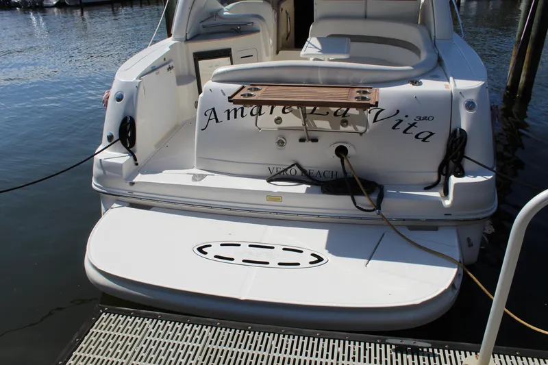 Slide: The Image of 2005 Sea Ray Sundancer 320 boat interior with white seating and table at dock. - 23