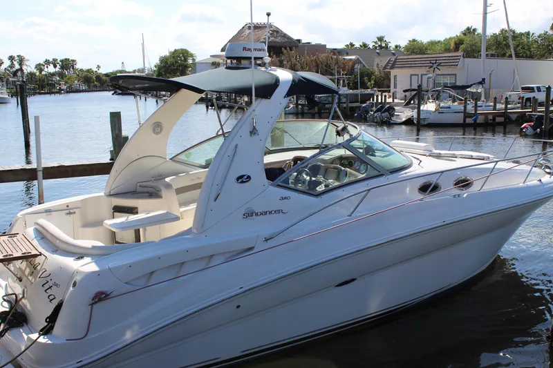 Slide: The Image of 2005 Sea Ray Sundancer 320 docked, featuring a spacious swim platform and elegant seating area. - 28