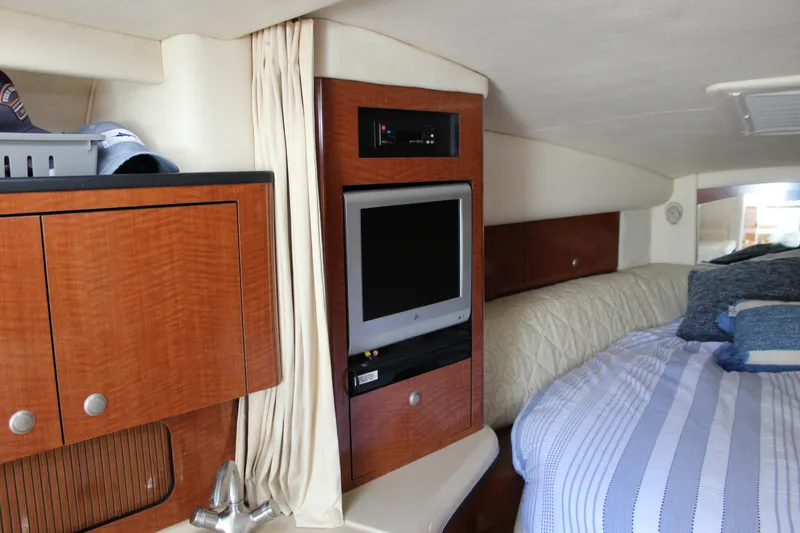 Slide: The Image of Interior of 2005 Sea Ray Sundancer 320 with TV, bed, and wooden cabinetry. - 32