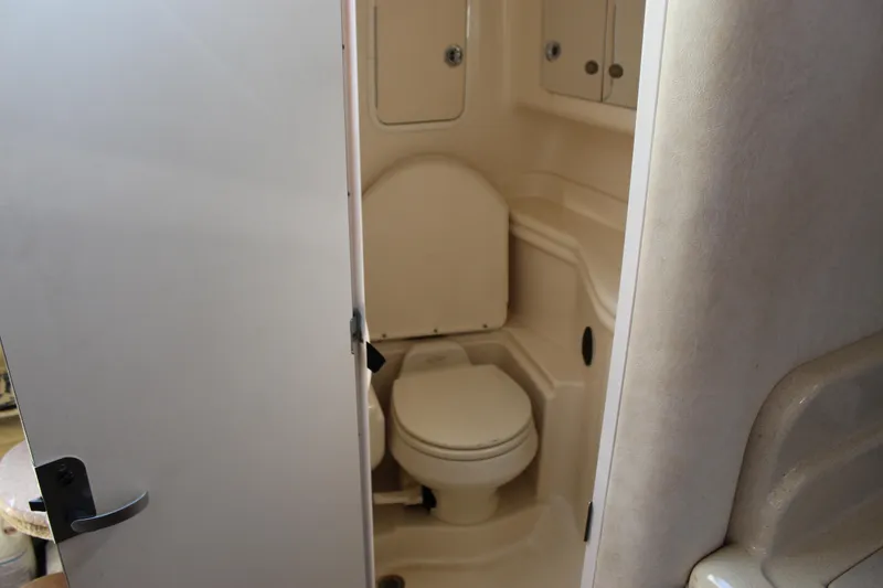 Slide: The Image of 2005 Sea Ray Sundancer 320 boat bathroom interior with toilet and storage cabinets. - 38