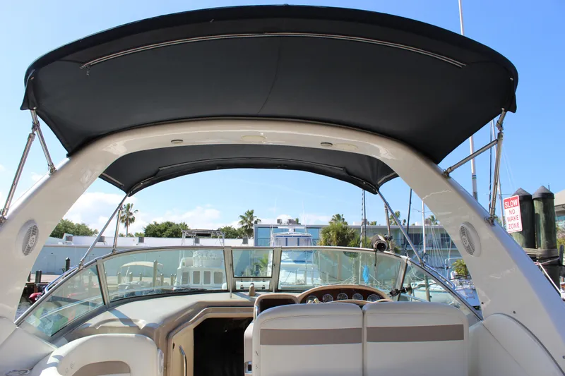 Slide: The Image of 2005 Sea Ray Sundancer 320 cockpit with steering wheel, gauges, and marina view. - 7