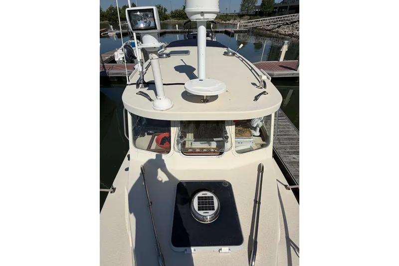 Slide: The Image of 1998 Rosborough RF-246 Sedan Cruiser docked, showcasing its deck and navigation equipment. - 18