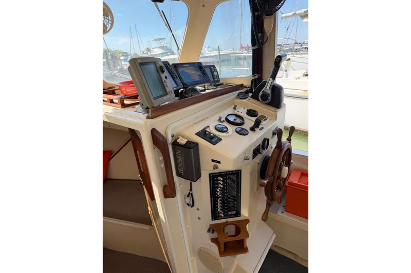 Slide: The Image of 1998 Rosborough RF-246 Sedan Cruiser helm with navigation instruments and wooden steering wheel. - 29