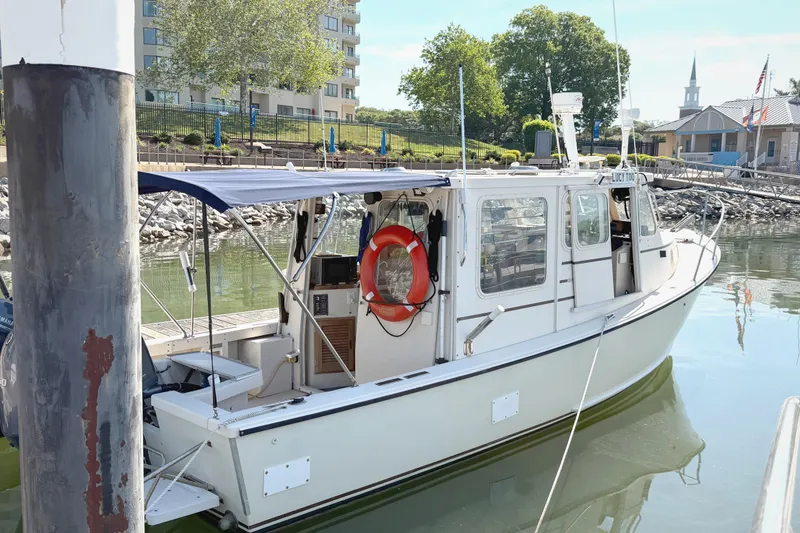 Slide: The Image of 1998 Rosborough RF-246 Sedan Cruiser docked at a marina with a blue canopy. - 3