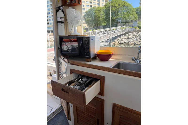 Slide: The Image of 1998 Rosborough RF-246 Sedan Cruiser interior with kitchen setup, microwave, and utensils. - 38