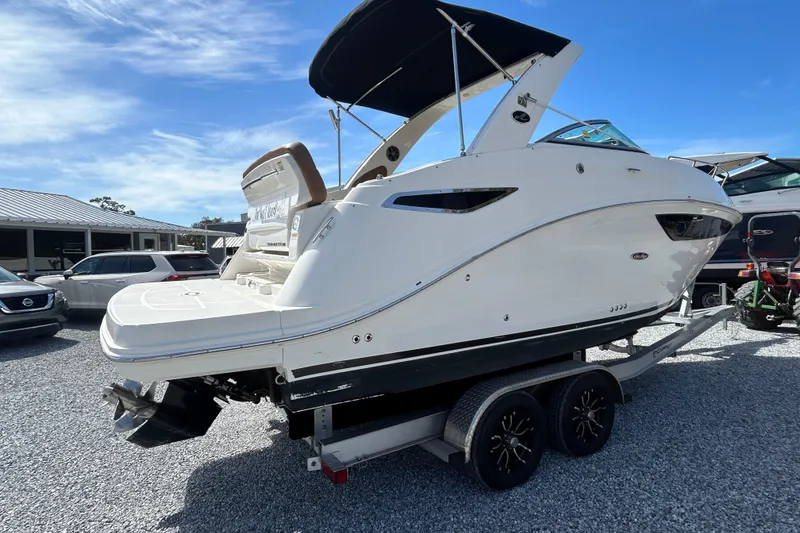 Slide: The Image of 2016 Sea Ray Sundancer 260 boat on trailer, white exterior, parked outdoors. - 15