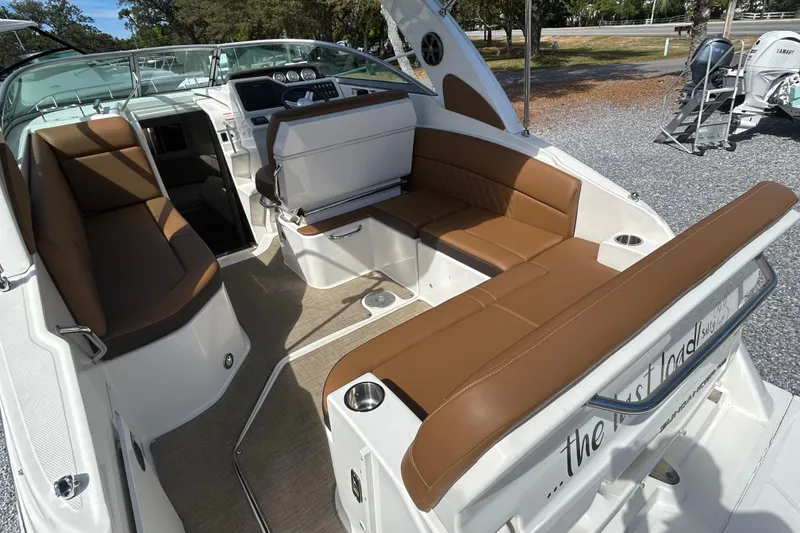 Slide: The Image of 2016 Sea Ray Sundancer 260 boat interior with brown seating and modern dashboard. - 18