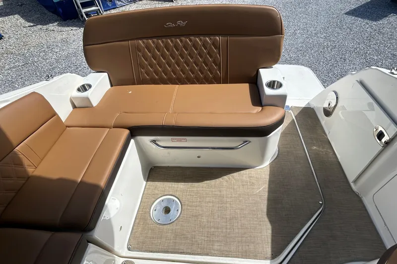 Slide: The Image of 2016 Sea Ray Sundancer 260 boat interior with brown leather seating and cup holders. - 20