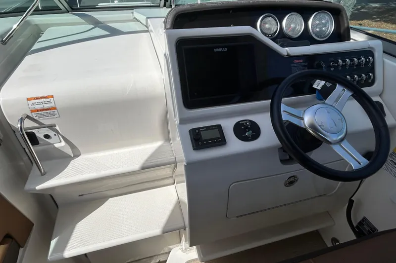 Slide: The Image of 2016 Sea Ray Sundancer 260 helm with steering wheel and control panel. - 23