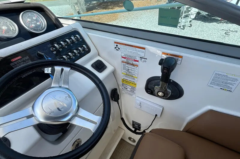 Slide: The Image of Steering console of a 2016 Sea Ray Sundancer 260 boat with controls and gauges. - 24