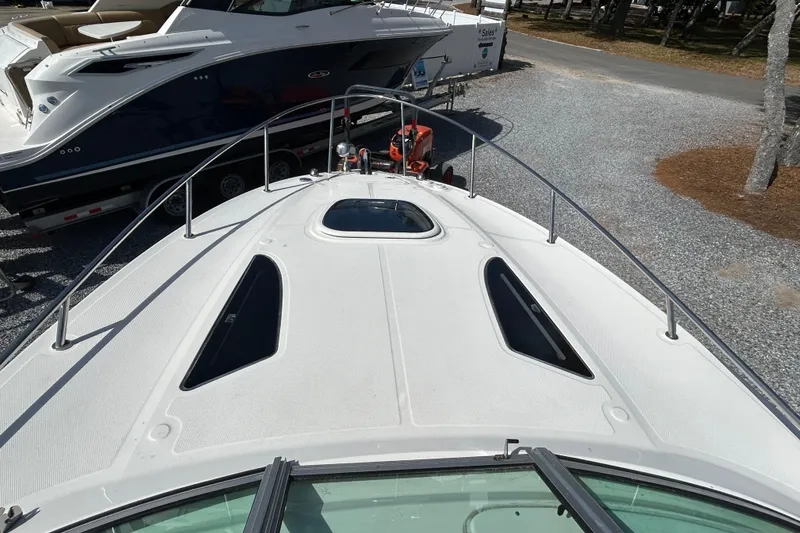 Slide: The Image of 2016 Sea Ray Sundancer 260 boat deck view, parked on gravel lot. - 25