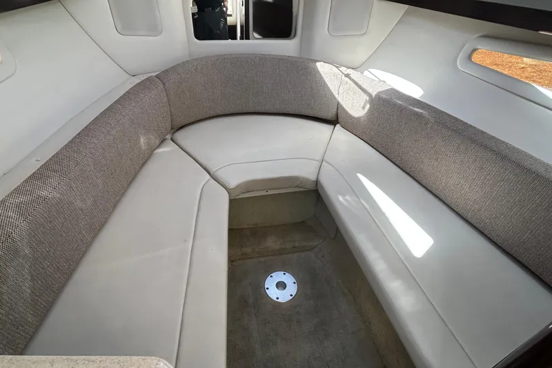 Slide: The Image of Interior cabin of 2016 Sea Ray Sundancer 260 with cushioned seating and natural light. - 26
