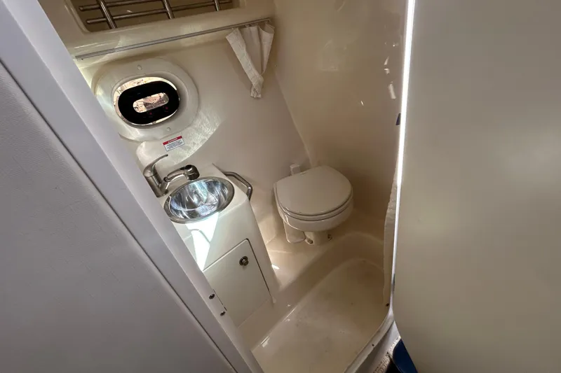 Slide: The Image of 2016 Sea Ray Sundancer 260 bathroom with sink, toilet, and porthole window. - 28