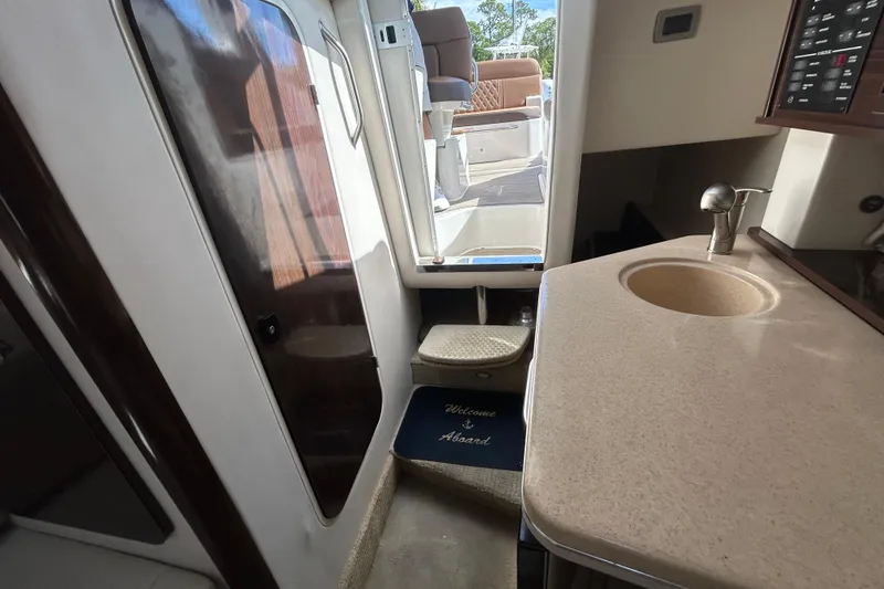 Slide: The Image of Interior view of 2016 Sea Ray Sundancer 260, featuring a compact sink and cabin entrance. - 29