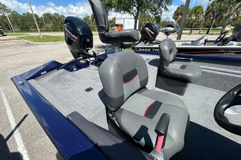 Slide: The Image of 2021 Tracker Pro Team 175 TF boat interior with Mercury engine, featuring gray and red seating. - 9