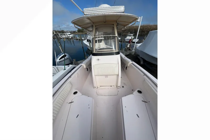 Slide: The Image of 2014 Grady-White Fisherman 230 boat docked, showcasing spacious deck and seating area. - 7