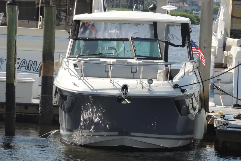 The Image of 2020 Sea Ray Sundancer 320 Outboard docked, featuring sleek design and American flag. - 0