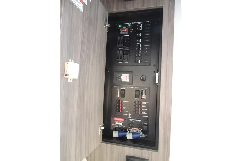 Slide: The Image of Electrical panel inside 2020 Sea Ray Sundancer 320 Outboard boat, showcasing circuit breakers. - 11