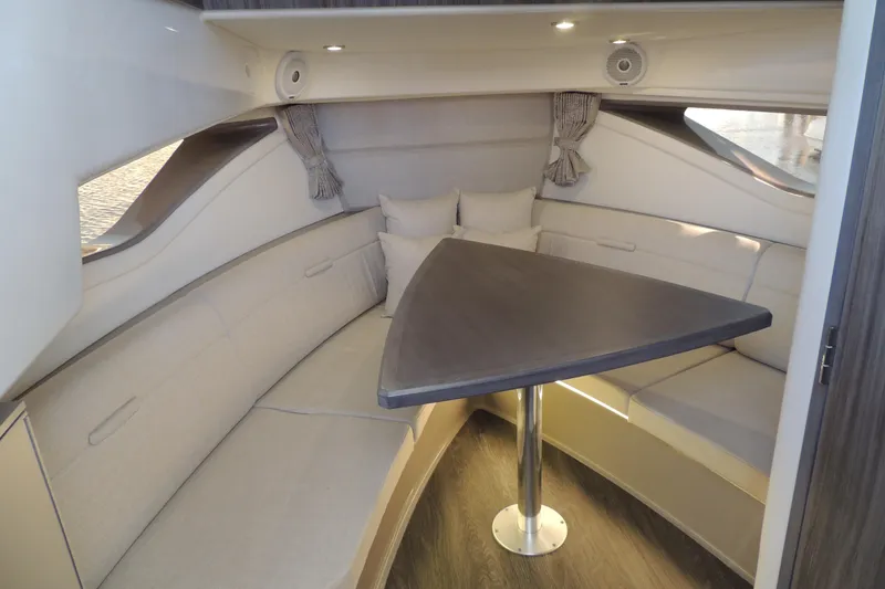 Slide: The Image of 2020 Sea Ray Sundancer 320 Outboard cabin interior with elegant seating and triangular table. - 14
