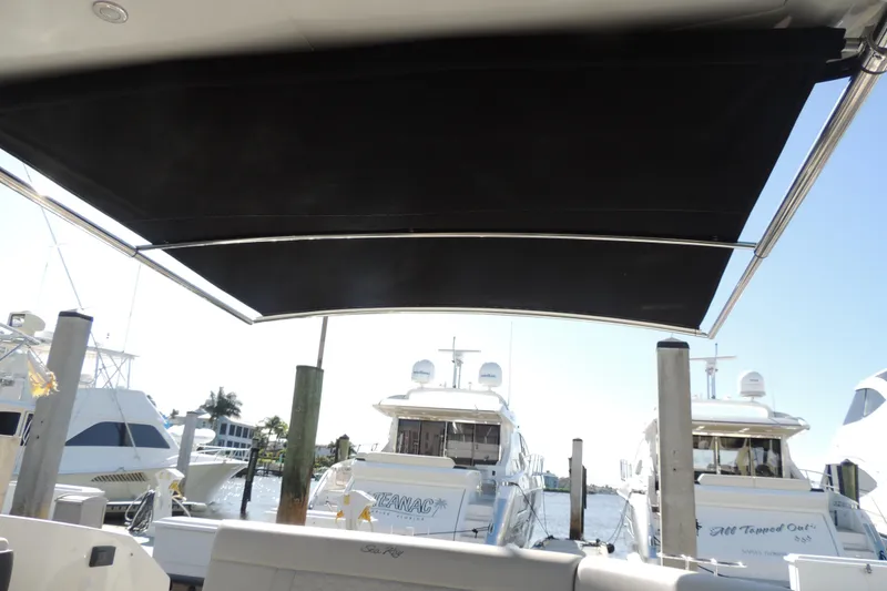 Slide: The Image of 2020 Sea Ray Sundancer 320 Outboard with extended sunshade at marina. - 2
