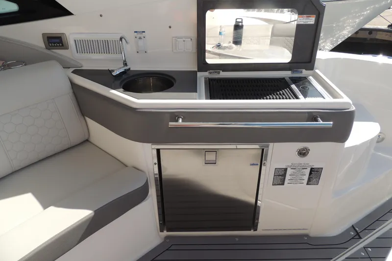 Slide: The Image of 2020 Sea Ray Sundancer 320 Outboard boat interior with kitchenette and seating area. - 20