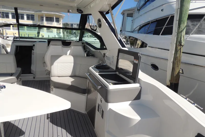 Slide: The Image of Interior of 2020 Sea Ray Sundancer 320 Outboard, featuring seating and kitchenette area. - 22