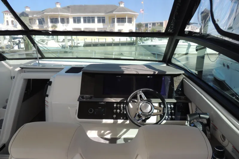 Slide: The Image of 2020 Sea Ray Sundancer 320 Outboard helm with modern controls and waterfront view. - 26