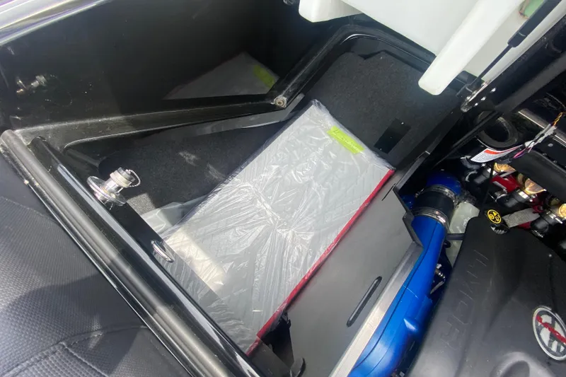 Slide: The Image of 2021 MasterCraft X26 engine compartment with visible components and storage area. - 14