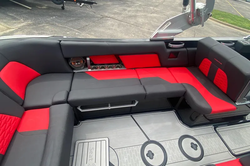 Slide: The Image of 2021 MasterCraft X26 boat interior with red and black seating, featuring cup holders and speakers. - 21