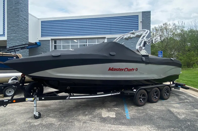 Slide: The Image of 2021 MasterCraft X26 boat on trailer, covered, parked outside a building. - 35