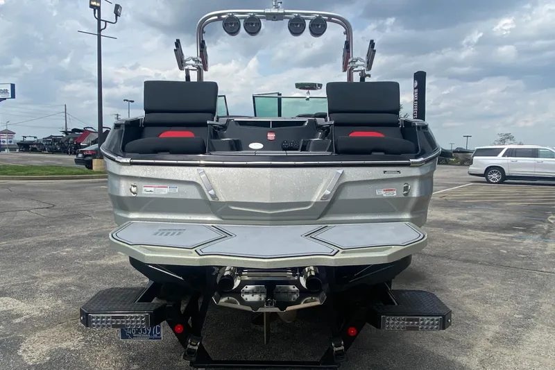 Slide: The Image of 2021 MasterCraft X26 boat, rear view, parked in a lot under cloudy skies. - 4