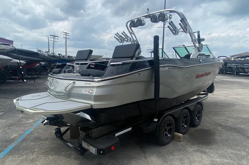 Slide: The Image of 2021 MasterCraft X26 boat on trailer, displayed outdoors under cloudy sky. - 5