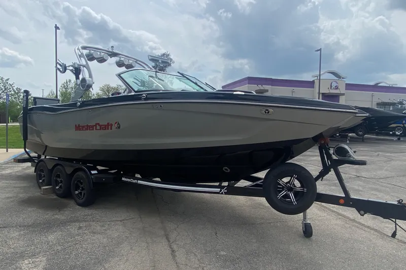 Slide: The Image of 2021 MasterCraft X26 boat on trailer under cloudy sky. - 7