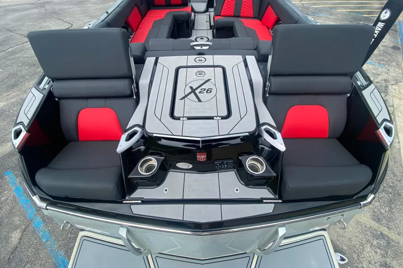 Slide: The Image of 2021 MasterCraft X26 boat interior with black and red seating, cup holders, and sleek design. - 8