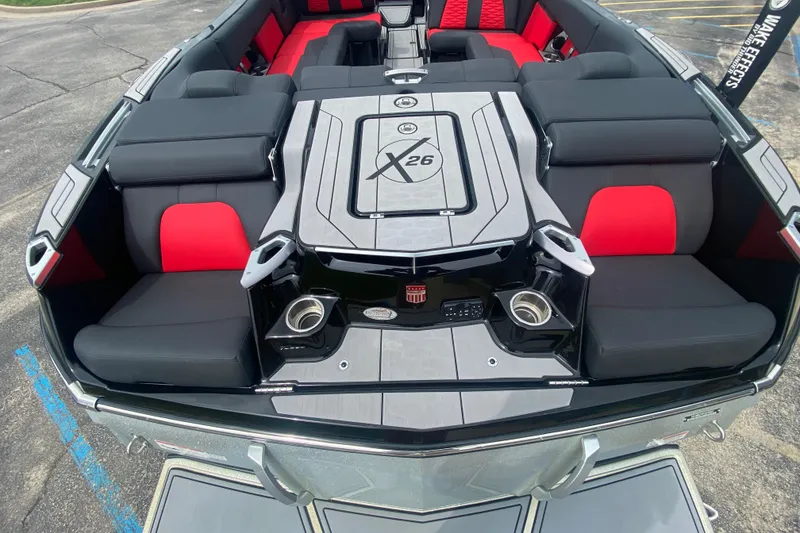 Slide: The Image of 2021 MasterCraft X26 boat interior with black and red seating, cup holders, and sleek design. - 9