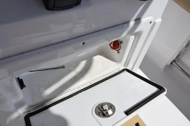 Slide: The Image of 2019 Sportsman Open 212 Center Console storage compartment with latch and wiring details. - 16