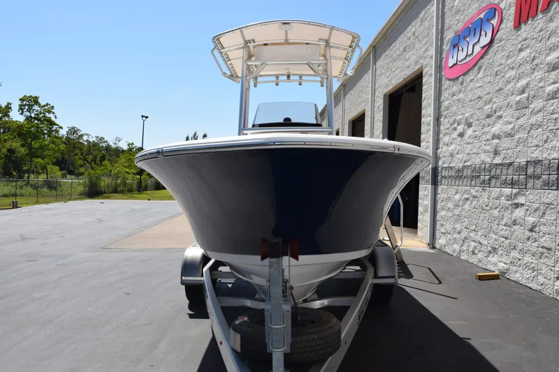 Slide: The Image of 2019 Sportsman Open 212 Center Console boat on trailer outside a building. - 2