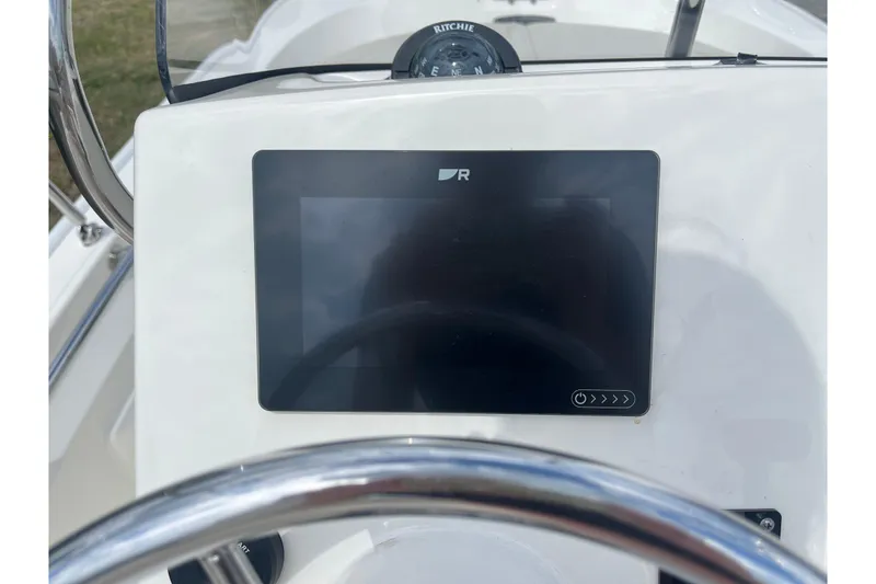 Slide: The Image of 2021 Boston Whaler 150 Montauk dashboard with navigation display and compass. - 13