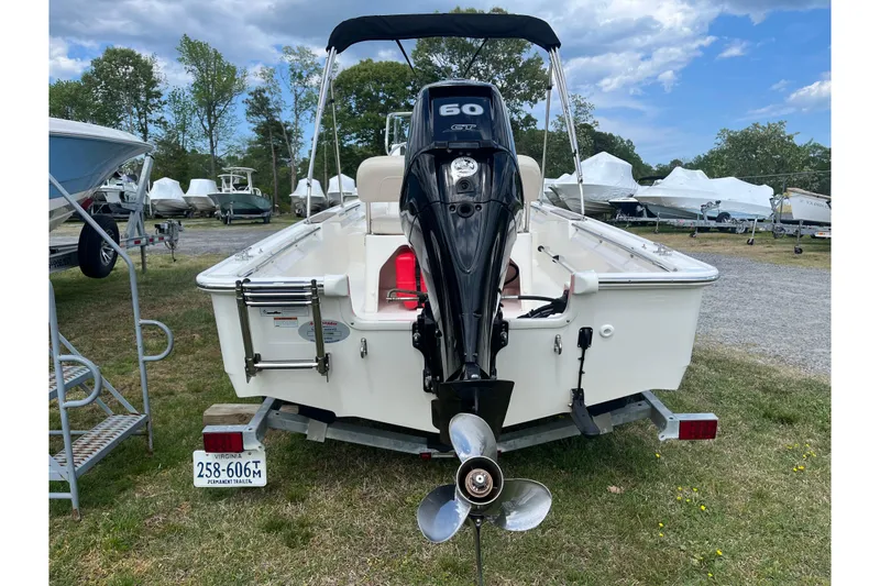 Slide: The Image of 2021 Boston Whaler 150 Montauk boat with outboard motor, parked on a trailer. - 19