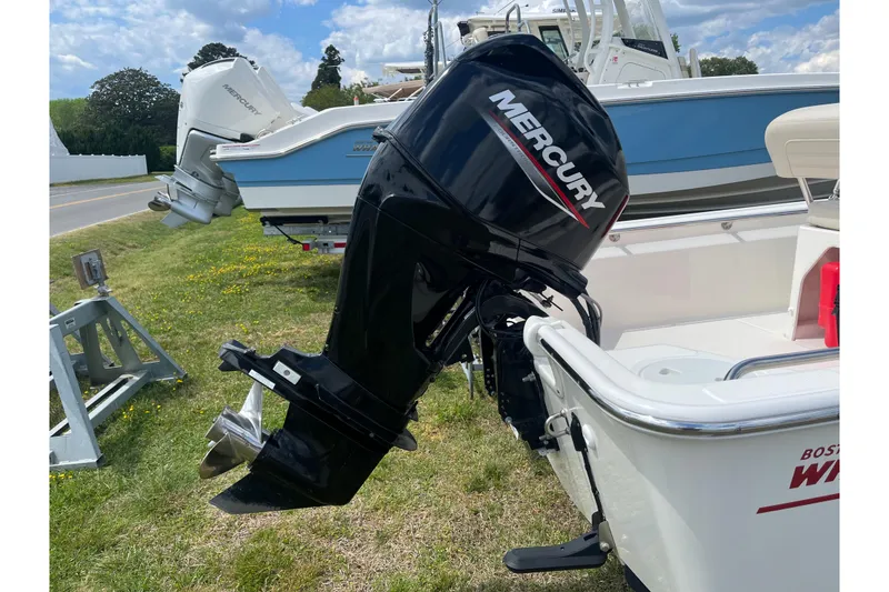 Slide: The Image of 2021 Boston Whaler 150 Montauk with Mercury outboard motor, parked on grass. - 20