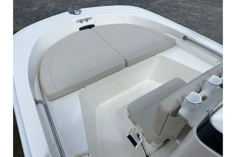Slide: The Image of 2021 Boston Whaler 150 Montauk boat interior with cushioned seating and cup holders. - 3